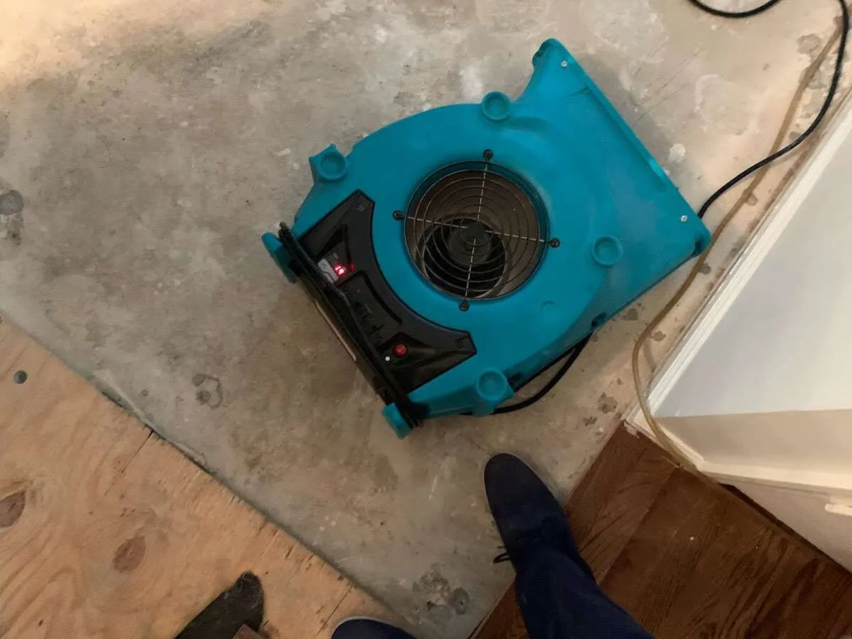 Air mover drying subfloor during Commercial Water Damage Restoration in Commerce City